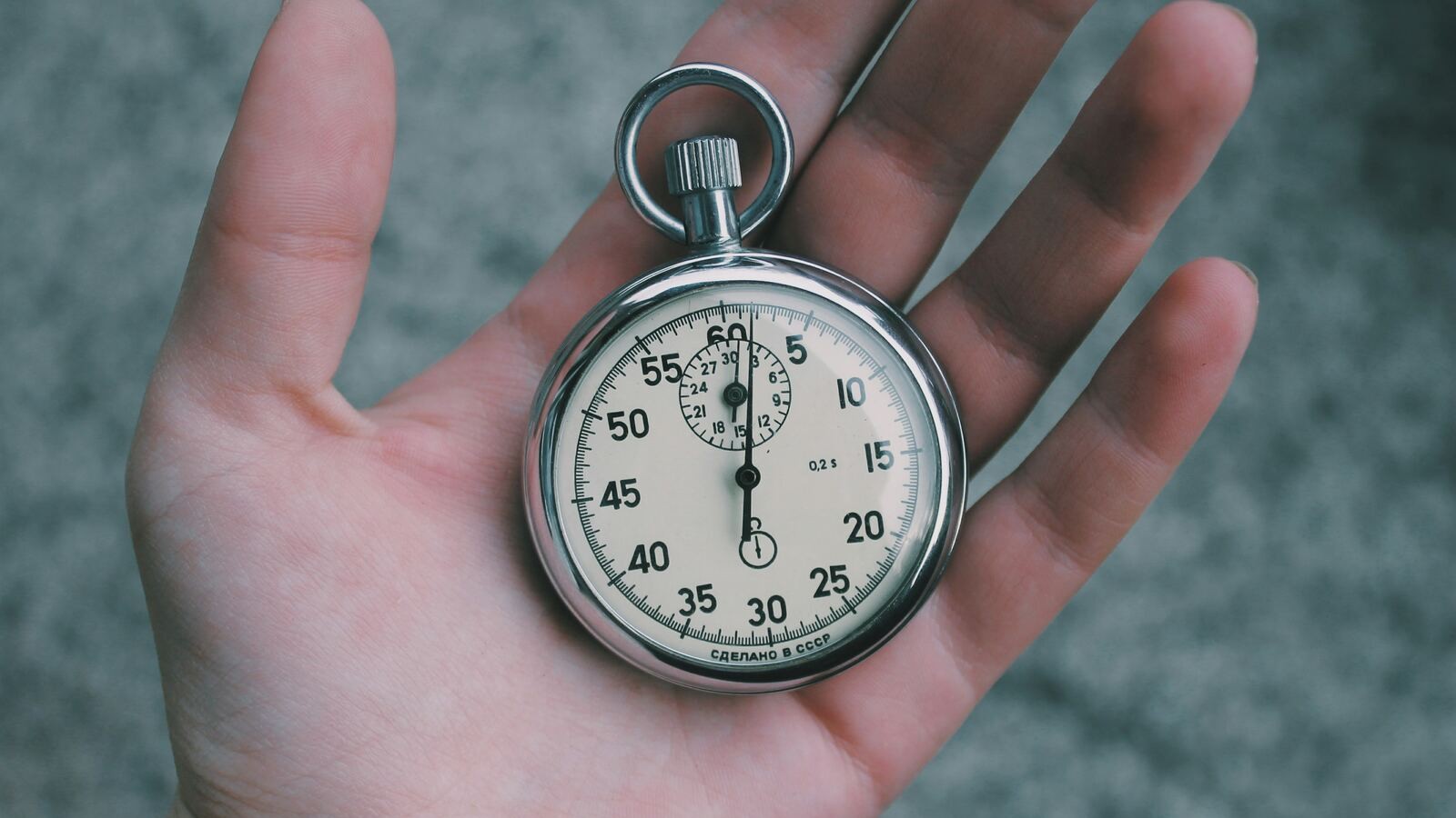 una mano nuda tiene in mano un cronometro che segna il tempo che passa